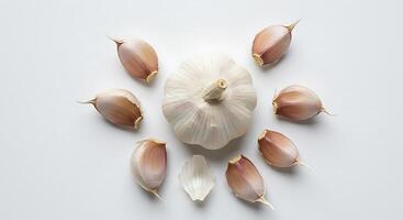 Arrangement of Fresh Garlic Bulb and Cloves on a White Surface photo