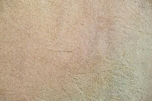 Golden sand texture background with soft patterns. Natural beach surface with fine grains and subtle ripples. photo