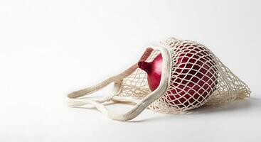 Red Onion in Reusable Mesh Bag Minimalist Zero Waste Concept photo