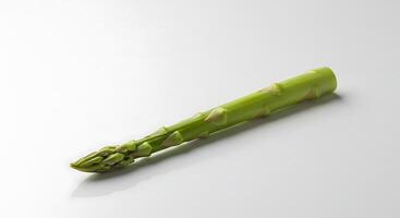Single Spear of Fresh Green Asparagus on a White Surface photo