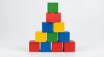 Stacking Colorful Wooden Blocks Into Pyramid Shape on White Backdrop photo