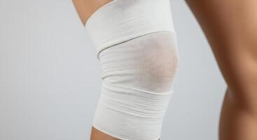 Knee Wrapped with White Bandage for Support and Compression photo