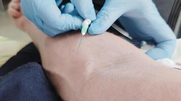Medical professional wearing gloves inserts IV needle into patient s arm, demonstrating a sterile environment, precision technique, and proper injection procedure video