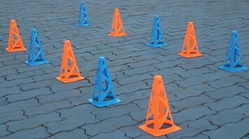 Orange cones and blue cones set up on a blue field for high school sports speed drills, photo