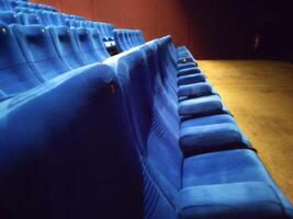 Rows of empty blue seats in a cinema hall for a large number of people. Cinema and theater halls for watching shows photo