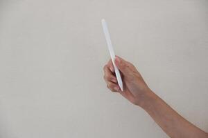 Technology Concept. One Hand using Tablet in Vertical axis with white stylus or pen and free screen on white background and clipping path, photo
