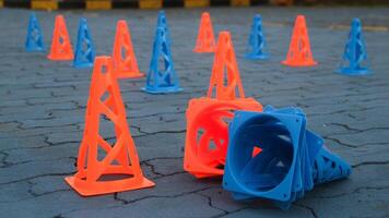 Orange cones and blue cones are set up on the blue field for speed training, photo