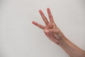 Close-up of hand showing number three gesture isolated on white background. photo