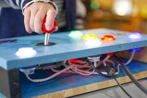 Child Playing with Colorful Arcade Joystick photo