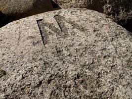 Carved Letter 'M' on Weathered Rock photo