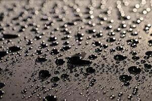 CloseUp of black Water Droplets on Dark and white Surface photo
