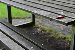 Red Lighter on a Weathered Picnic Table photo