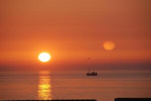 Serene Sunset Over Ocean with Ship photo