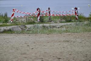Caution Tape Marking Restricted Area by Water photo