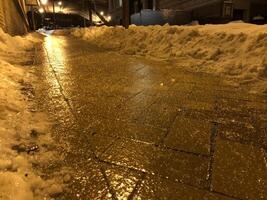 Frozen and dangerous Sidewalk at Night with Snow photo