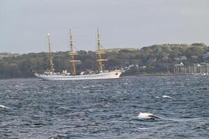 Gorch Fock Sailing on Calm Sea with Coastal Background photo