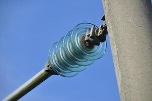 Glass Insulators on Power Line Against Blue Sky photo