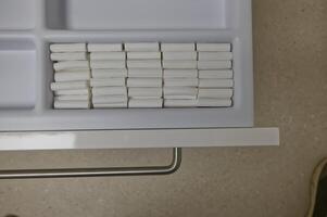 A neatly organized drawer containing rows of white cotton rolls used by the dentist photo