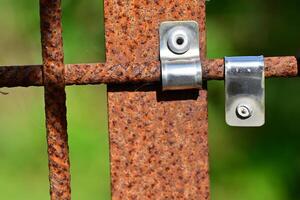 Close-up of Rusty Metal Fence with Shiny Latch photo