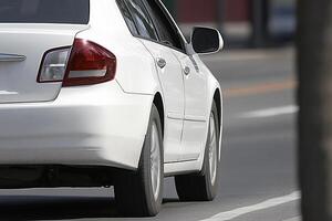 A white car is parked on the side of the road photo