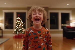 A young boy is laughing in front of a christmas tree photo