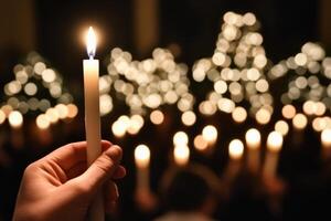 A person holding a lit candle in front of a crowd of people photo