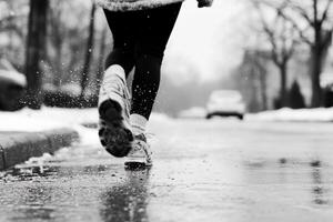 A black and white photo of a person running in the snow