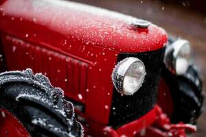 A close up of a red tractor with snow on it photo