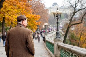 A man in a brown coat and hat walking down a path photo