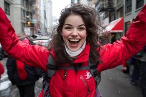 A woman in a red jacket is smiling and holding her hands up photo