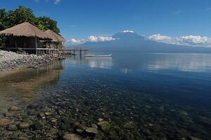 A boat is sitting on the shore of a lake photo