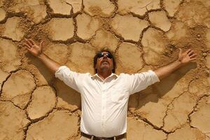 A man with his arms outstretched in front of a cracked wall photo