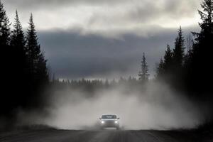 A car driving on a dirt road with fog photo
