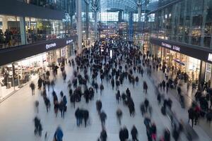A crowd of people walking in a shopping mall photo