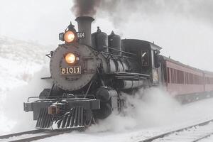 A steam engine train traveling through the snow photo