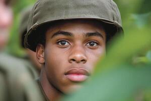 A young man in a military uniform looks at the camera photo