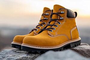 A pair of yellow boots on top of a rock photo