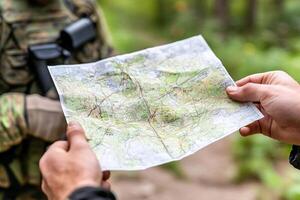 A soldier holding a map in front of another soldier photo