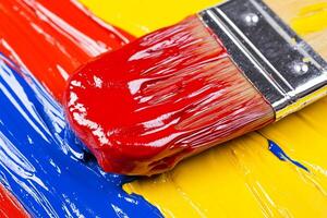 A paint brush is sitting on a colorful paint photo