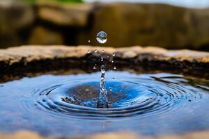 A water drop is falling into a water fountain photo