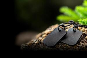 Two black dog tags on a rock photo