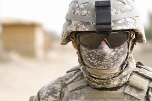 A soldier wearing a face mask and sunglasses photo