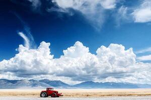 A red tractor sits in the middle of a field photo