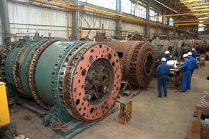 A large machine in a factory with workers photo