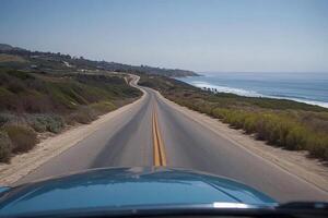 A car driving down a road with the ocean in the background photo