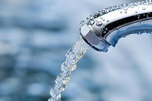 A close up of a faucet with water flowing out photo
