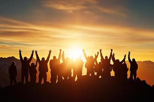 Silhouette of people standing on top of mountain with hands raised in the air photo