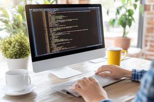 A woman is typing on a computer with code on the screen photo