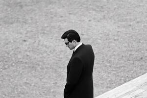 A man in a suit and tie standing on a wooden platform photo