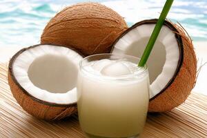 A coconut half and a glass of coconut juice photo